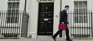 Chancellor of the Exchequer George Osborne leaves his official residence No 11 Downing Street in London with his traditional red dispatch box as he departs for the House of Commons to deliver his annual budget speech