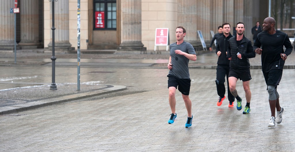 Facebook founder Mark Zuckerberg runs with bodyguards in Berlin, Germany