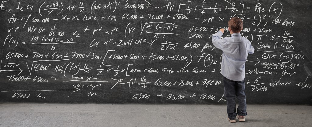 A child writes equations on a blackboard