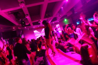 A woman dances on a bar in a nightclub