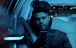 A man in a car reads a text on his phone