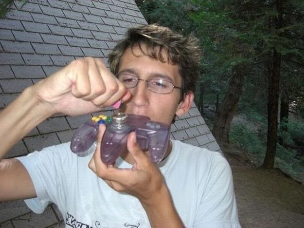 A man using a games controller as a bong