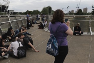 A young woman plays Pokemon Go at the Olympic Stadium, London.