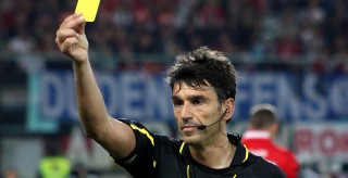 A soccer referee shows a yellow card