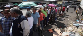 People line up to buy government subsidized food at a state-run market in Venezuela