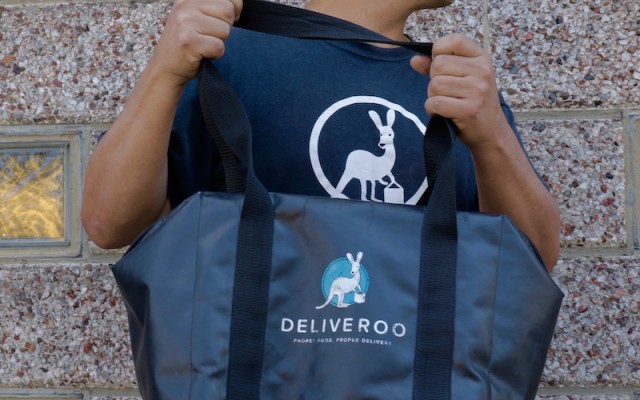 A Deliveroo driver holds his delivery bag