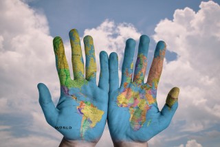 A map of the world painted on a pair of hands