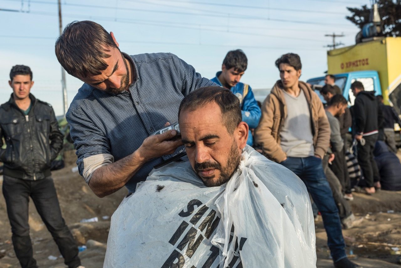 A man has his haircut at the Idomeni refugee camp