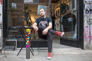 Man sitting in front of shop in Greece.