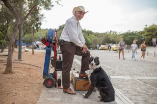 A street musician and his dog in Greece.