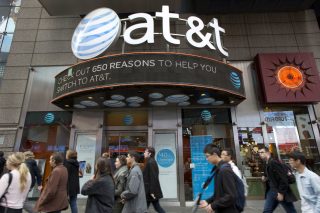 People walk past an AT&T building.