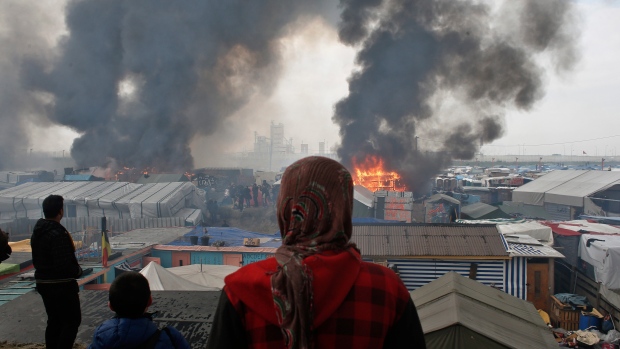 Migrant watching fires in Calais camp