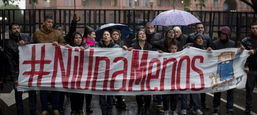 People hold a banner that reads in Spanish 