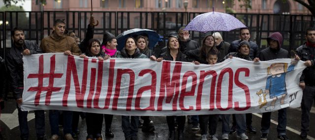 People hold a banner that reads in Spanish 