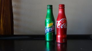 A bottle of Sprite and a bottle of Coca Cola