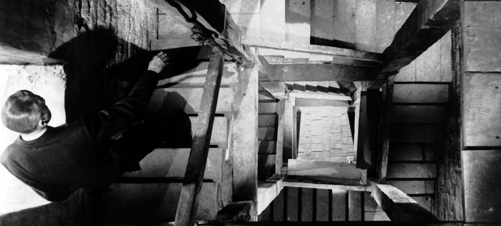 A still from Vertigo - James Stewart walks on stairs