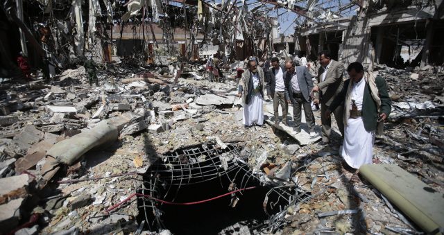 Members of Higher Council for Civilian Community Organization, inspect a destroyed funeral hall as they protest against a deadly Saudi-led airstrike on a funeral hall six days ago, in Sanaa, Yemen