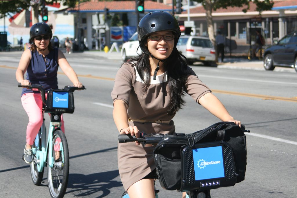 Two girls ride city bikes in San Jose.