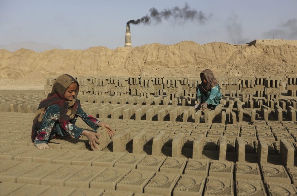 Afghan girls work in a brick factory