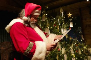 Santa Claus reading letters in his grotto.