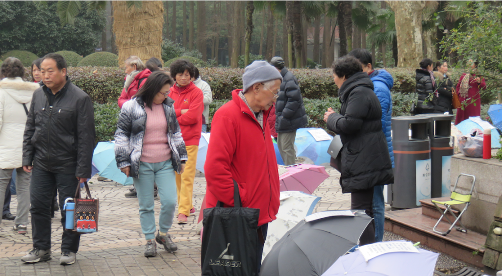 Parent inspects umbrellas at Shanghai marriage market.