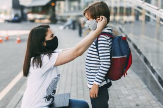 mother-adjusts-her-sons-mask-a-mother-and-child-on-their-way-to-school-or-kindergarten-during-a_t20_ynp9e0