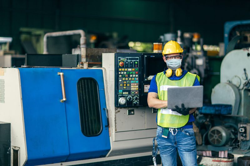 Chinese worker operating machinery in a factory