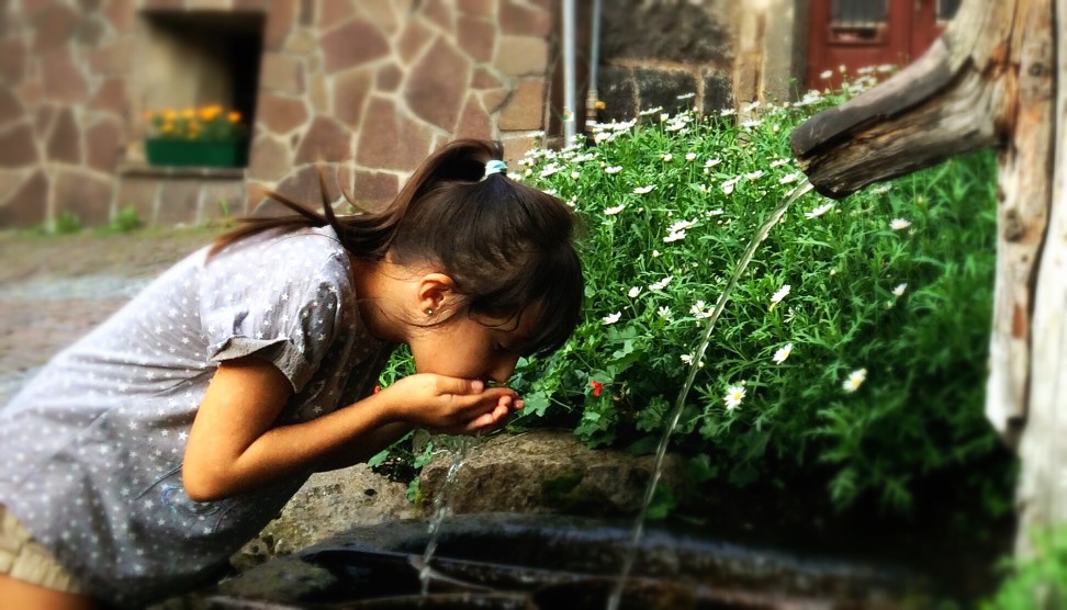 Girl drinking water from a fountain