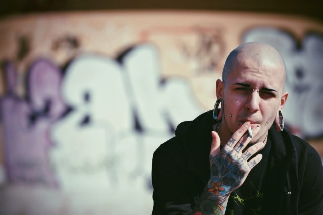 Shot of a man with tattoos, smoking