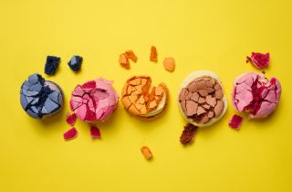 broken round macarons with crumbs on a yellow background, delici